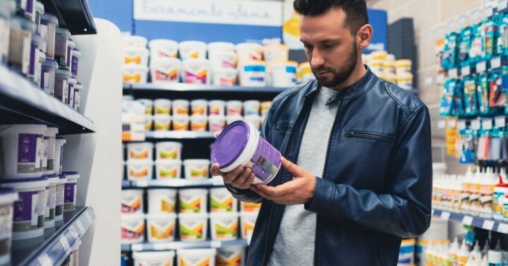 A buyer in a hardware store in the paint and varnish department chooses paint for building a house