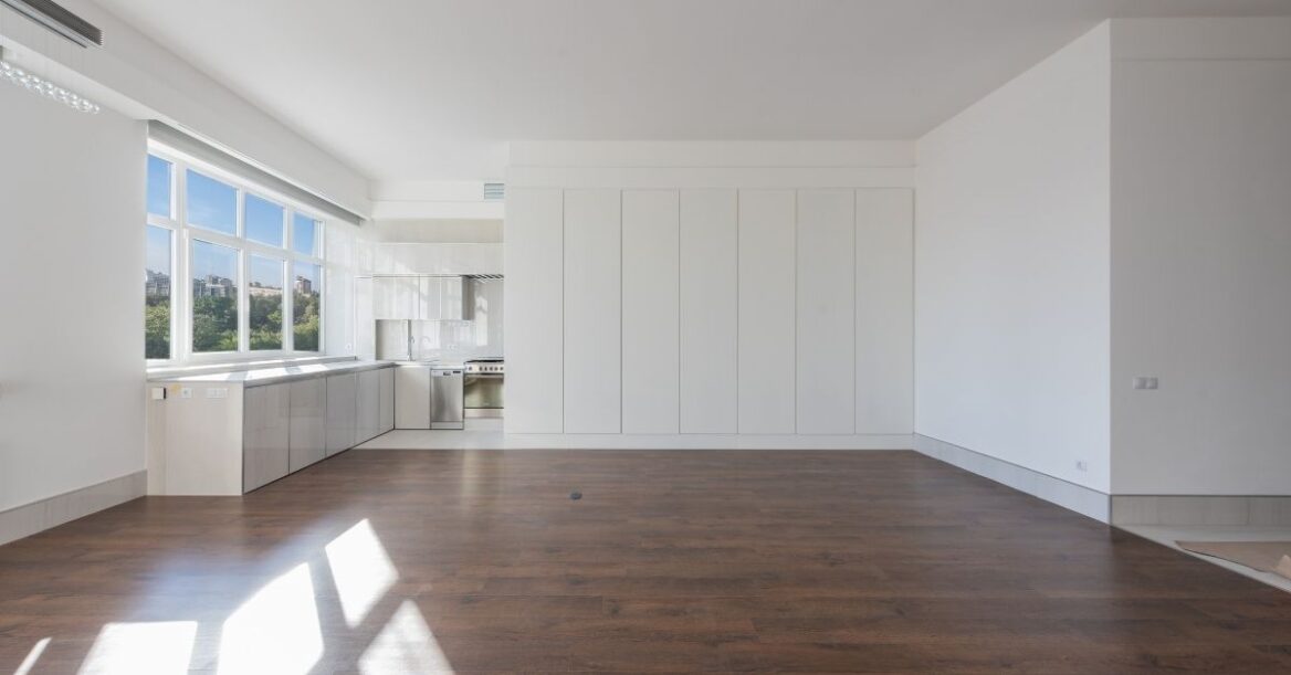 Empty Kitchen with Wooden Flooring and White Walls.