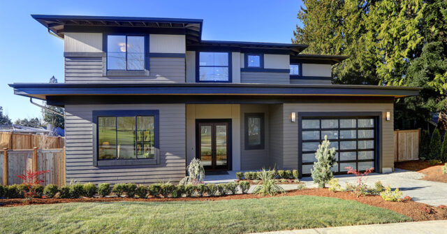 Grey painted weatherboard house with blue exterior trim around the windows, garage and guttering.